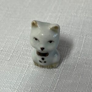 small vintage ceramic figurine of a cat, resembling Japanese Maneki-neko lucky